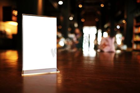 木制菜单摄影照片_菜单框架站在酒吧餐厅咖啡厅的木桌上。