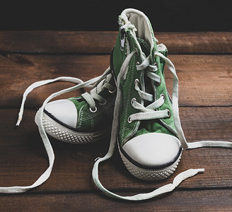 一双鞋运动鞋摄影照片_一双非常破旧的绿色纺织鞋