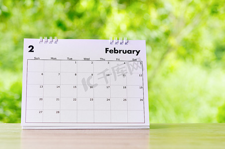 2022 年 2 月日历台，供组织者在木桌上计划和提醒