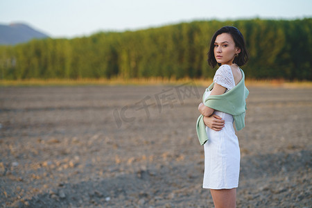 亚洲女人，走在乡下，穿着一件白色的裙子。