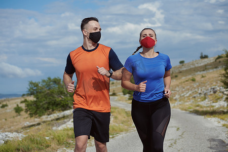 奔跑的运动员摄影照片_戴着面具在大自然中奔跑的情侣