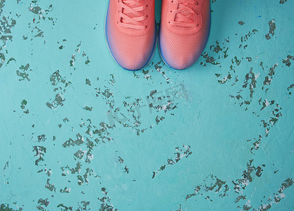 绿色背景上一双带鞋带的粉色运动鞋