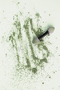 分散的橄榄色和绿色眼影，带涂抹器，隔离在白色背景中，美容和化妆概念，垂直拍摄