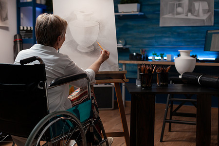 专注于残疾的退休艺术教师在铅笔画花瓶模型中创作艺术作品