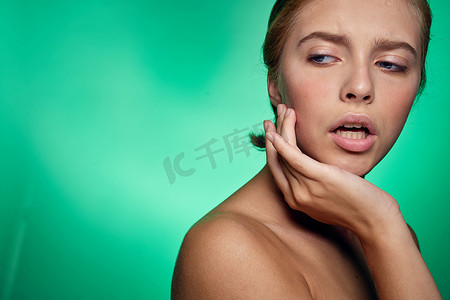 皮肤清洁的女性面部手术美容裸肩绿色背景