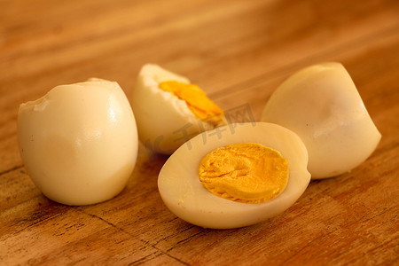 煮熟的鸡蛋，在木质背景上切成两半