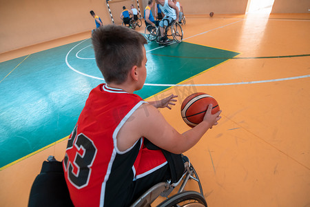 男孩坐在轮椅上，为大竞技场的篮球比赛做准备。