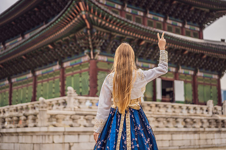 韩服女摄影照片_在韩国宫殿穿着韩服的年轻白人女游客。