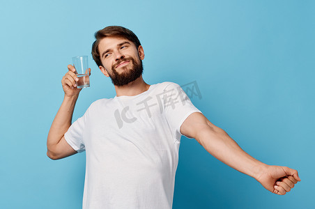男人在蓝色背景生活方式饮料裁剪视图中的玻璃杯中测试水