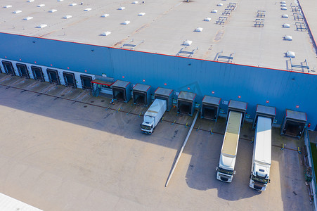 许多卡车正在卸载商品的工业装卸区的空中拍摄。