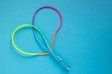 用于蓝色背景智能手机的多彩多姿的彩虹 USB 电缆。