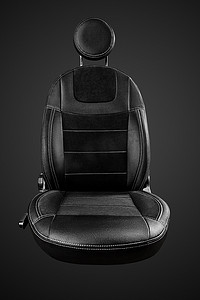 黑色汽车座椅摄影照片_舒适的驾驶员汽车座椅，带有黑色背景隔离的圆形头枕