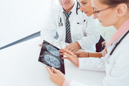 医生团队在平板电脑上讨论 X 射线