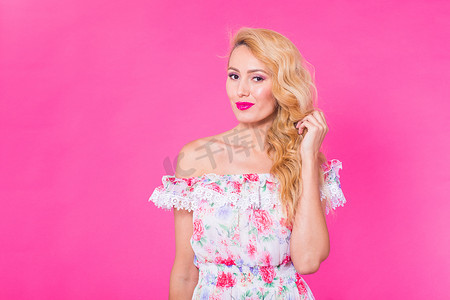 漂亮的女孩穿着裙子摆在粉红色的背景上与 copyspace 的工作室。