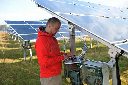 工程师在太阳能电池板厂区使用笔记本电脑