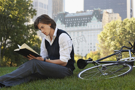 坐在草坪上看书的男人