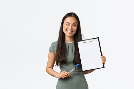 成功的微笑亚洲女企业家用空白纸展示剪贴板，好像炫耀她的结果，进行调查或为小型在线商店写下客户信息，管理自己的业务