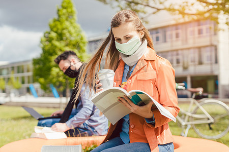 戴口罩在大学校园学习的女学生