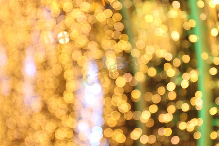 闪光金黄色摄影照片_散景背景金黄色色彩缤纷的圣诞快乐，新年快乐散景照明在夜间背景上闪耀，散景闪光，金色豪华背景纹理，闪闪发光的壁纸