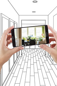 手持智能手机的手上显示房屋走廊绘图的照片
