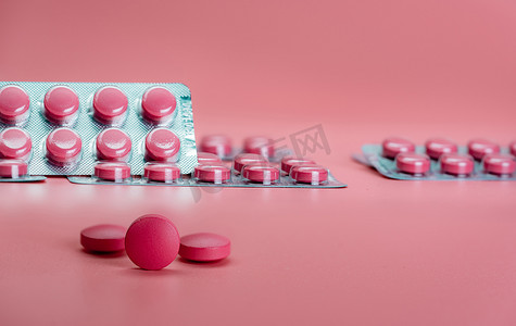 粉红色的药丸和粉红色背景的泡罩药丸。