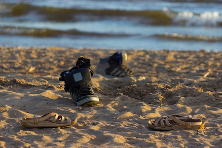沙滩背景上有海浪的运动鞋