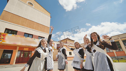 快乐的俄罗斯学校毕业生在上学的最后一天伸出双手。