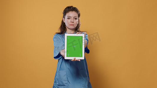 打字显示摄影照片_医生手持平板电脑和打字显示绿屏模型设计的医疗数据的肖像