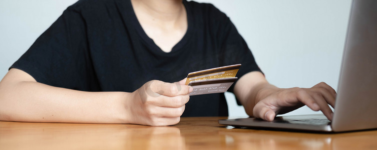 使用信用卡和智能手机笔记本电脑进行网上购物的特写女性手