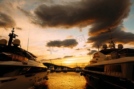 橙色日落背景下停泊在黑山港的游艇