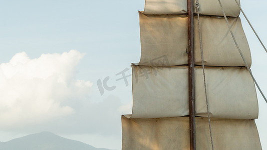 帆摄影照片_木桅上的布帆在天空的特写下