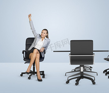 微笑的女商人坐在椅子上举起右手