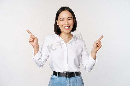 美丽的亚洲女性的形象，手指左右指着，做出决定，显示两种变体选择，站在白色背景上