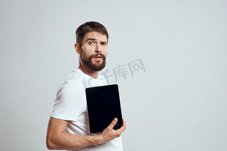 手拿平板电脑的情绪化男人触摸屏新技术浅色背景裁剪视图复制空间