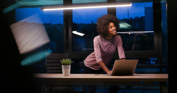 在夜间启动办公室使用笔记本电脑的黑人女商人