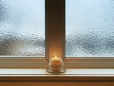 饮品磨砂质感图标摄影照片_磨砂窗户窗台上的蜡烛