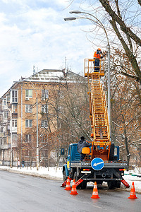 冬季工人摄影照片_道路服务人员在冬季检查街道照明工作。