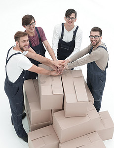 欢快的搬家工人靠在白色背上隔离的一堆盒子上