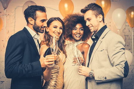 新年团年摄影照片_男人，在新年或生日聚会上打开一瓶香槟