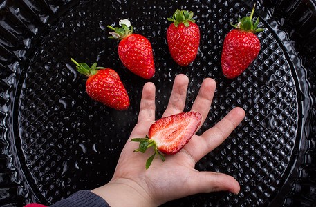 手里拿着甜甜成熟的草莓果子