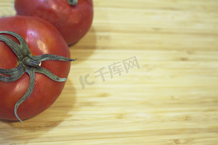 木切板上两个红熟的西红柿