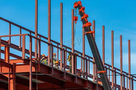 建筑工人用起重机固定铁梁。