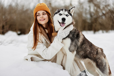 快乐的年轻女子冬装在雪地寒假遛狗