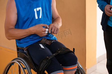 一名残疾篮球运动员坐在轮椅上准备比赛。职业篮球比赛的准备工作。
