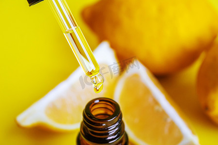 蓝黄科技背景图摄影照片_黄色背景上的柠檬精油。
