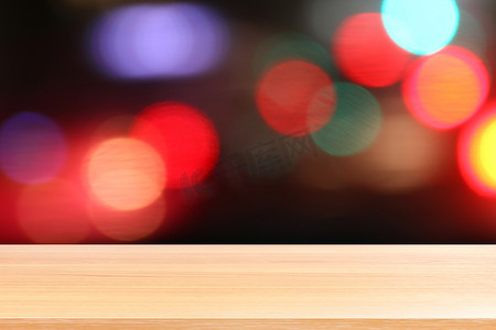 新店开业空前钜惠摄影照片_彩色散景光抽象背景上的木板，抽象散景夜光多色背景上的空木桌地板，木桌板空前彩色散景多色光束灯