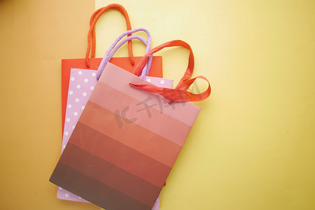 产品购物袋摄影照片_橙色背景的多色购物袋的顶视图