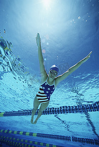 女游泳运动员在游泳池游泳时穿着美国泳衣