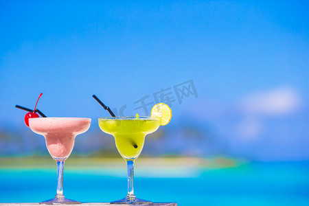 热带白色海滩上的两杯美味鸡尾酒