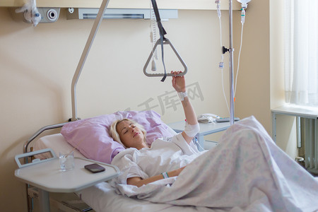 术后护理摄影照片_卧床不起的女性患者在医院护理中手术后康复。